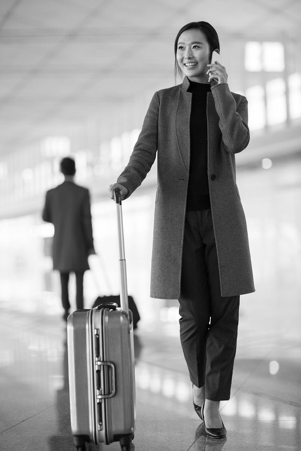 Woman with suitcase on phone